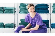 infermiera seduta in uno spogliatoio indossando una divisa chirurgica Barrier