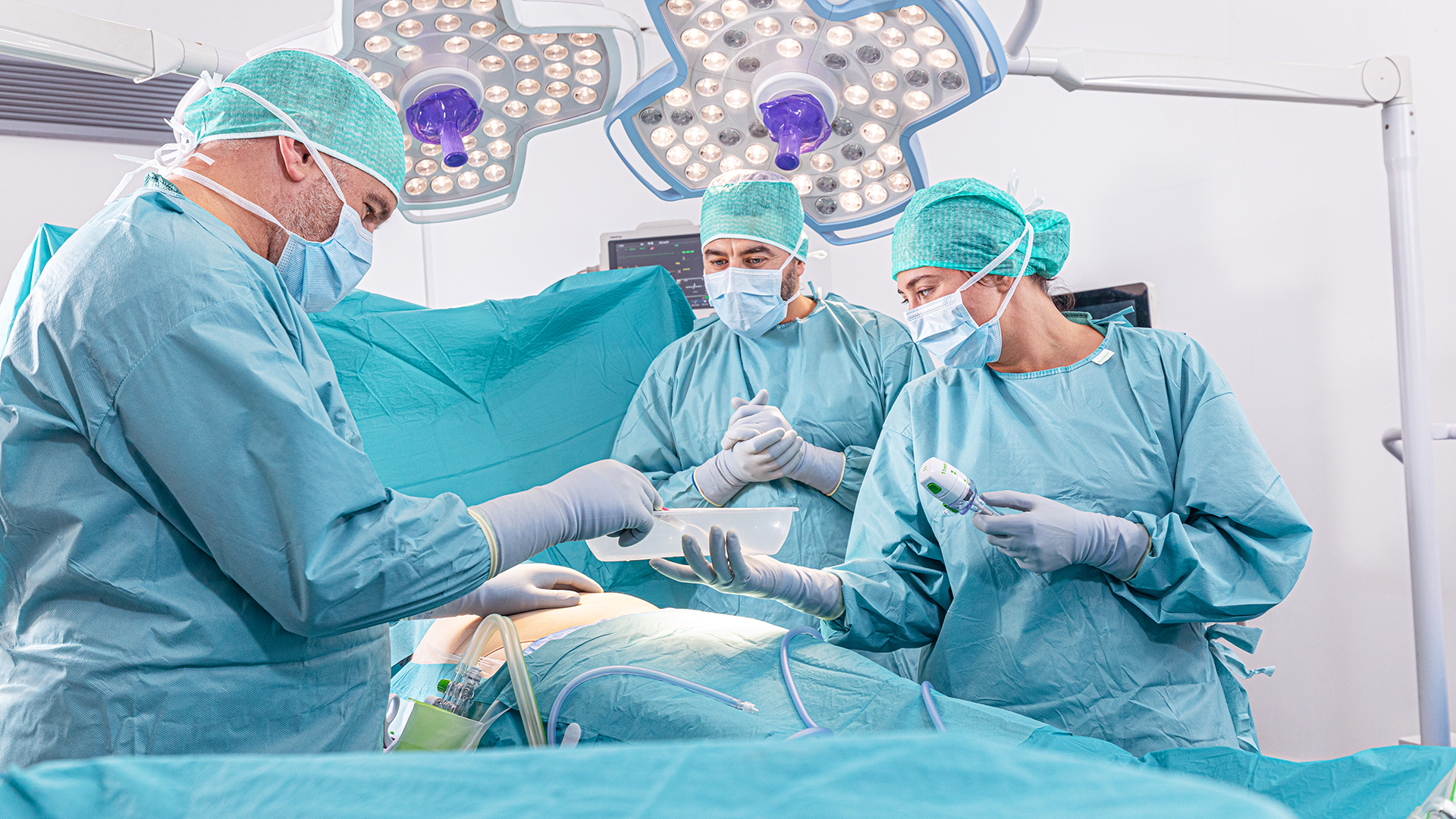 Un chirurgien prend un instrument chirurgical sur un plateau pendant une intervention