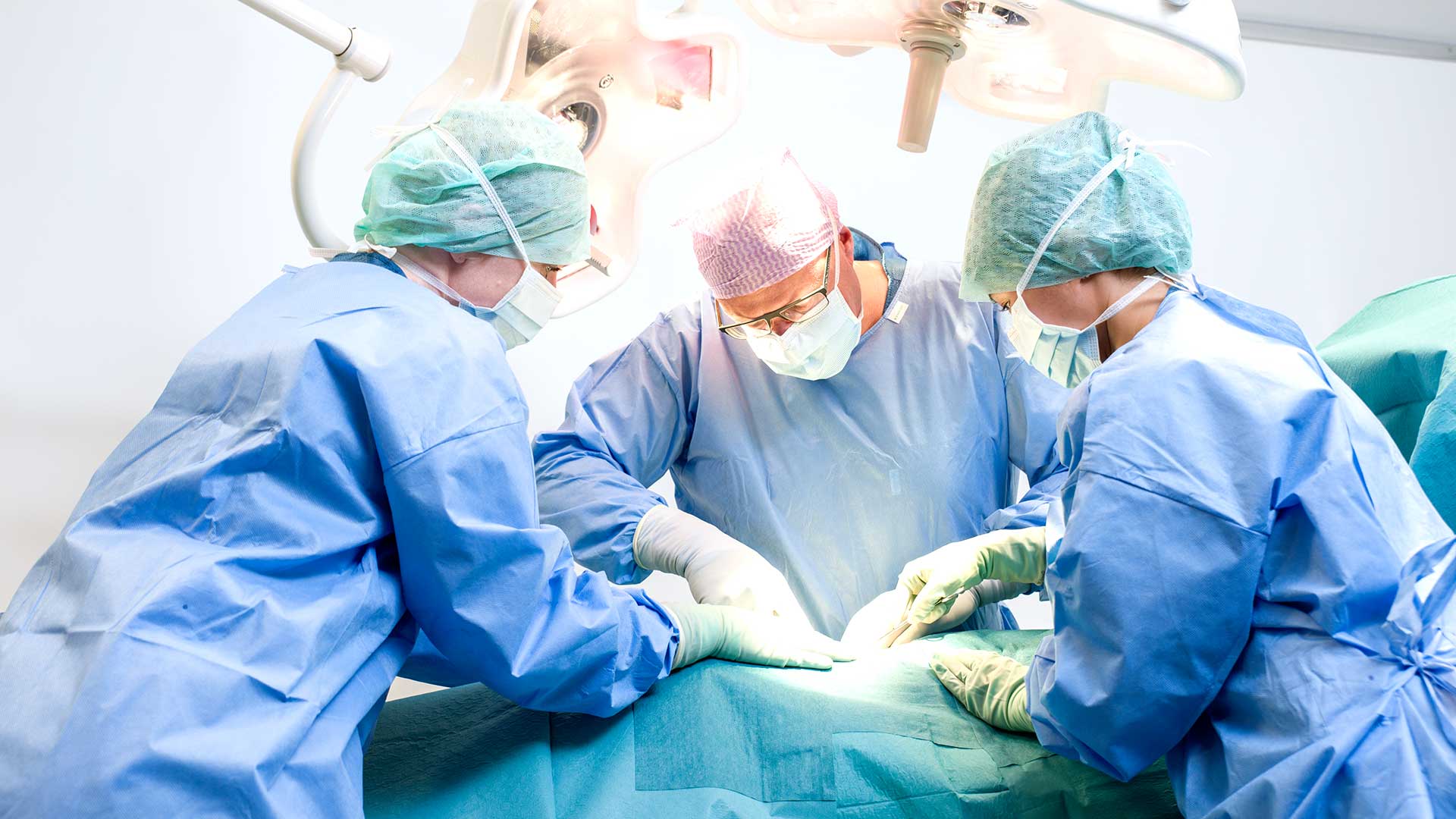 Chirurgo e infermieri mentre effettuano un intervento in sala operatoria